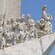 A sculpture featuring explorers with objects that define their contributions to each port of discovery